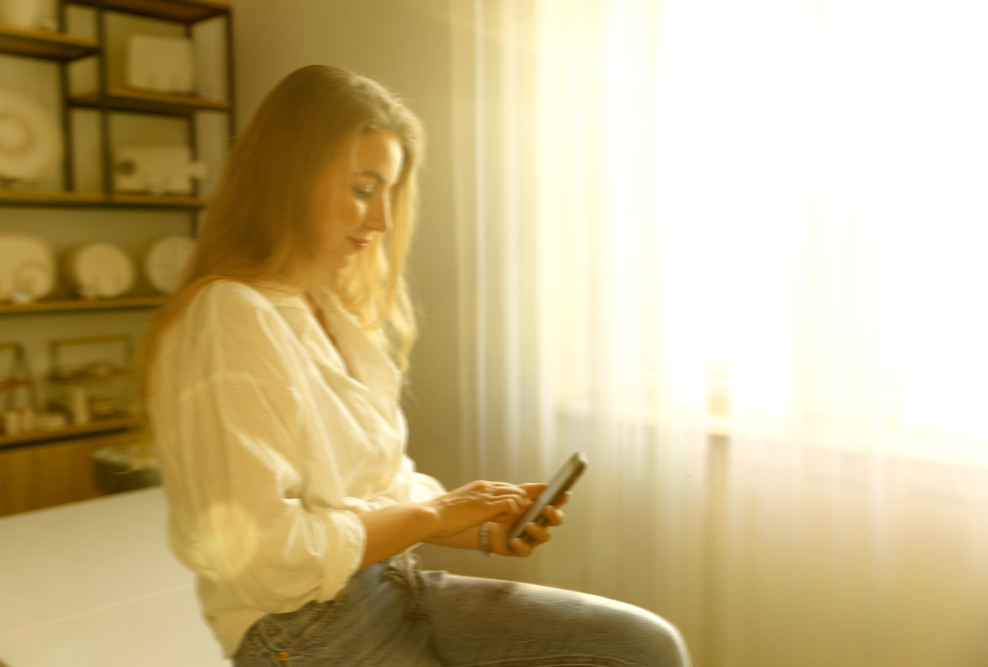 Woman on phone in sunlit kitchen