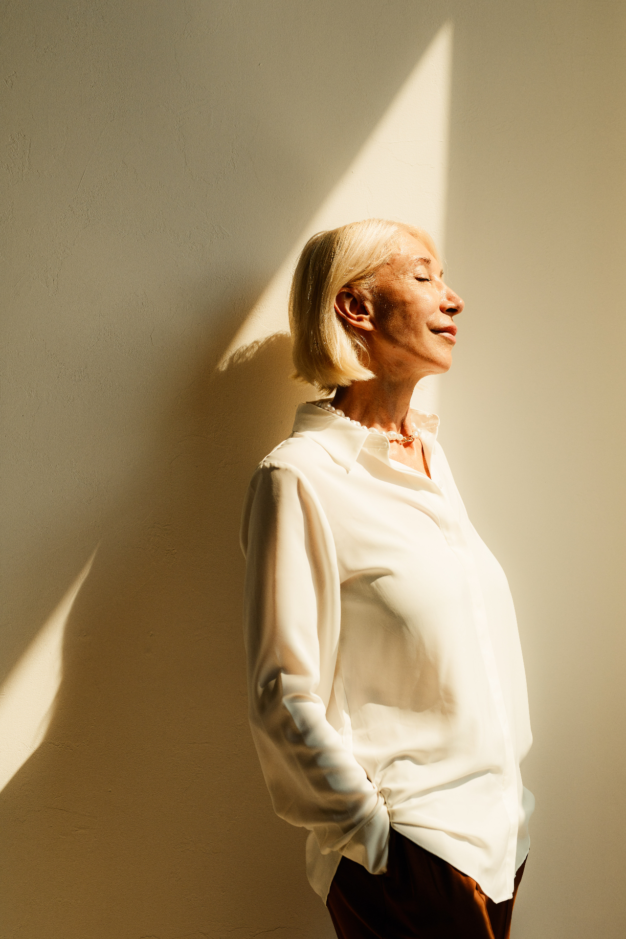 Woman in a white blouse standing in warm sunlight